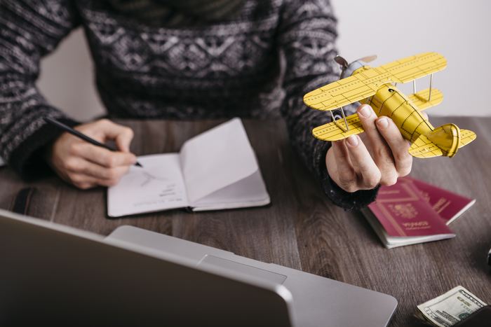 Man holding model airplane planning a trip / Sources Getty Images