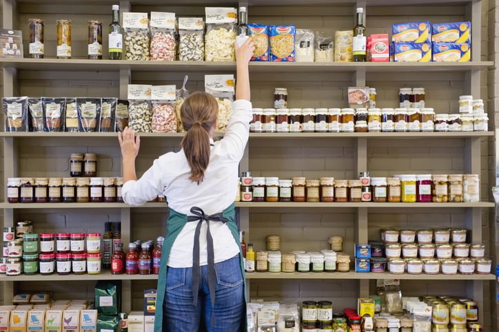 Une femme qui travaille dans un supermarché de dos