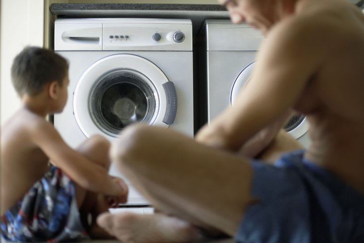 Père et fils en train de faires les tâches ménagères égalité